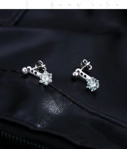 Macro view of silver geometric earrings with blue-green moissanite and butterfly backings