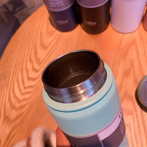 Detail of double-walled vacuum insulated bottle rim with smooth stainless steel texture