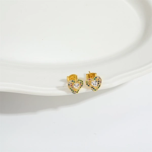Retro gold heart stud earrings with colorful zircon stones on white ceramic plate