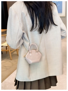 Pink mini woven jelly bag with chain strap styled on a model in a grey blazer