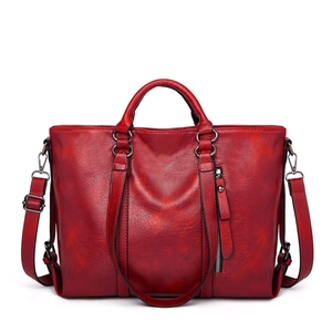 Red leather tote bag with handles and detachable shoulder strap on white background