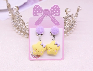 Detail of yellow star ear clips with purple bows on pink card for girls