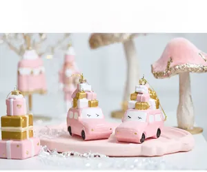 Detailed view of pink Christmas ornaments with car and mushroom shapes on a tray