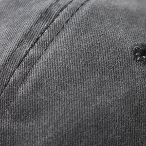 Macro shot of durable black twill fabric with reinforced double stitching on the baseball cap