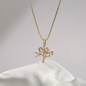 Elegant gold tree of life necklace with cubic zirconia pendants on white silk background