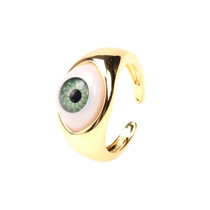 Macro detail of adjustable gold ring featuring a realistic green evil eye resin centerpiece