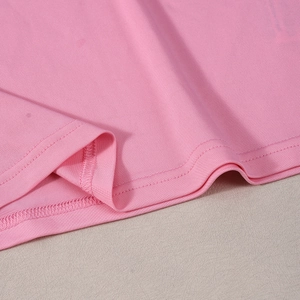 Macro-opname van dubbele stiksels en roze gebreide textuur aan de zoom van kleding