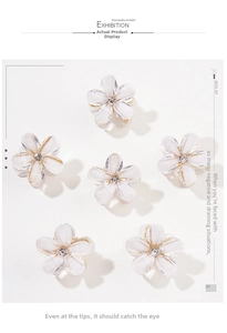 Detail of six mini flower hair claws with crystal centers and gold metal base
