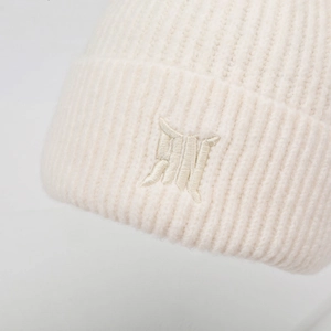 Primo piano di un berretto in maglia a coste bianco con logo ricamato
