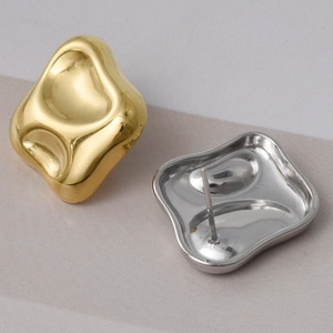 Irregular liquid metal stud earrings in 18k gold and silver finishes on a beige backdrop