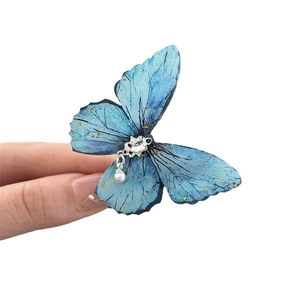 Elegant blue butterfly hair clip with shimmering rhinestones and a hanging pearl charm