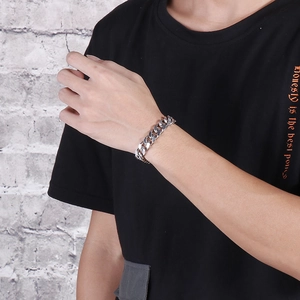 Nahaufnahme eines silbernen Edelstahl-Panzerarmbands am Handgelenk eines Mannes