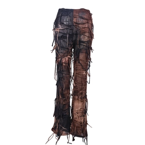 Dettaglio dei pantaloni patchwork a vita alta con frange invecchiate e design stringato