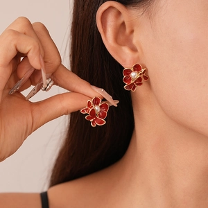 Elegant red enamel flower and butterfly earrings with white pearls and gold edges on model
