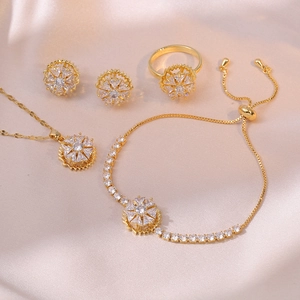 Luxurious gold jewelry set with white cubic zirconia flower motifs on champagne silk