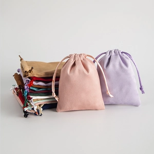 Detail of soft faux suede drawstring jewelry pouches in pastel pink and lavender shades