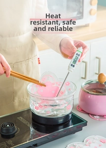 Heat-resistant pink cherry blossom table mat being tested in boiling water at 98.1 degrees