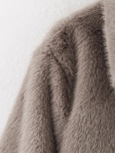 Close-up of brown-gray faux fur jacket showing the soft plush texture and seam detail