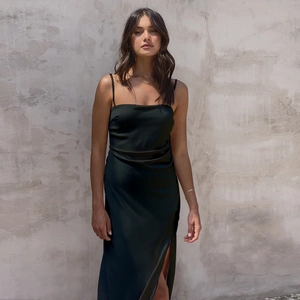 Detail of the elegant side slit on a sleek black satin midi dress for women