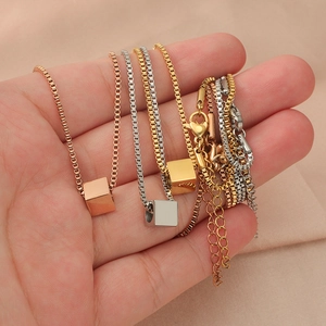 Minimalist square cube pendant necklace in gold silver and rose gold held in hand