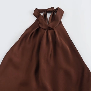 Close-up of elegant halter neck tie and pleated detail on coffee brown satin midi dress