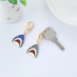 Detail of blue and grey shark head metal keychains with gold heart-shaped connectors