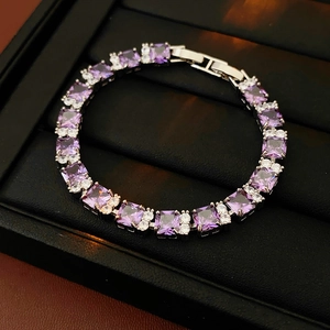 Detalle de pulsera con circonita violeta sobre cuero negro con cierre metálico