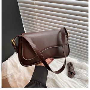Close-up of the fine stitching and matte leather texture on this dark brown retro bag