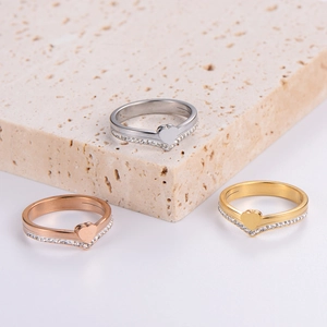 Three minimalist stainless steel heart-shaped rings in gold, silver, and rose gold