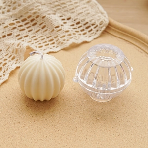 Spherical geometric acrylic candle mold with finished ribbed pillar candle on a cork base
