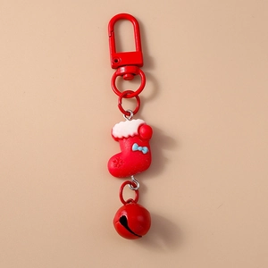 Close-up of a festive red Christmas stocking keychain with metal ring and small bell