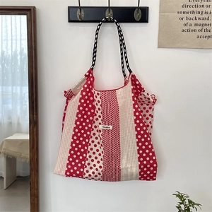 Détail du sac cabas en toile à pois rouges et blancs avec poignée en corde tressée