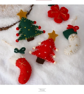 Detailed view of handmade wool felt Christmas tree ornaments and stockings with gold embroidery