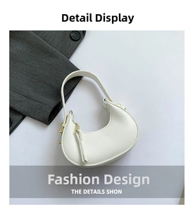 Close-up of white crescent hobo bag featuring litchi texture and gold zipper detail