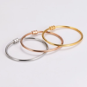 Three-piece stainless steel bangle set in gold, rose gold, and silver finishes