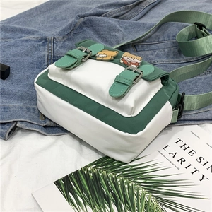Cute green and white nylon crossbody bag with cartoon pins and adjustable shoulder strap