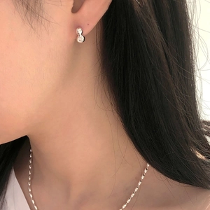 Detail view of a model wearing S925 silver olive bead necklace and elegant stud earrings