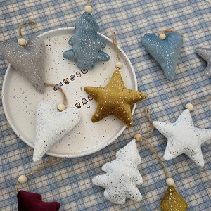 Detailed view of glitter fabric plush Christmas ornaments with stars and wooden beads