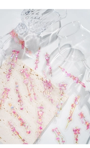 Detail of pink bow and gemstone stickers on a clear glass and marble surface