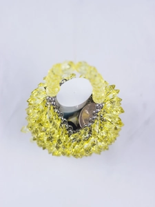 Macro shot showing internal capacity of handmade yellow beaded handbag with items