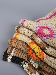 Detailed view of hand-crocheted straw hat patterns in multiple vibrant color options