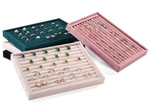 Macro detail of velvet jewelry display trays with parallel grooves in multiple colors