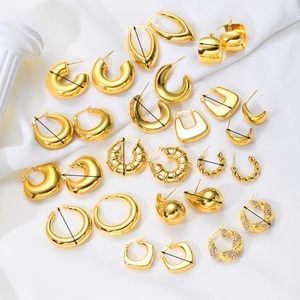 Set of minimalist geometric gold-plated C-shaped earrings and studs on a stone base