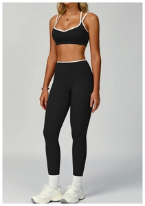 Dettaglio del set yoga nero con bordini bianchi, reggiseno con scollo a V e leggings a vita alta