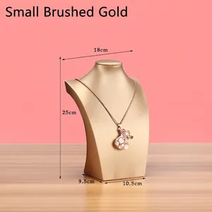 Detail view of small brushed gold necklace display bust with dimensions on pink background