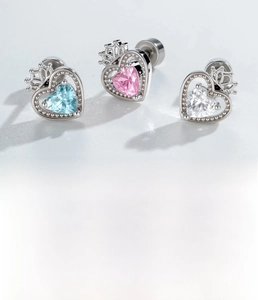 Detail von silbernen Herz-Ohrringen mit Zirkonia-Steinen in Blau, Rosa und Weiß aus Titanstahl