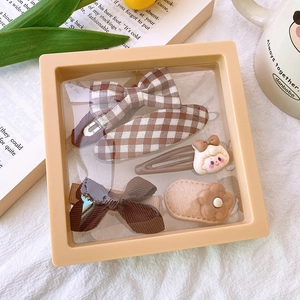 Close-up of 4pcs brown and beige fabric hair clips in a clear gift display box
