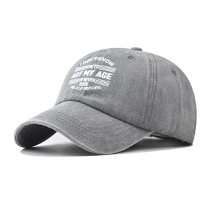 Close-up of gray washed cotton baseball cap with vintage worn texture and white embroidery