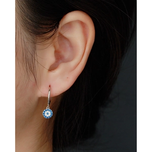 Macro detail of S925 sterling silver evil eye hoop earring with blue and white crystals