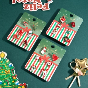 Coffret de boucles d'oreilles de Noël avec bonhomme de neige et renne sur fond vert festif